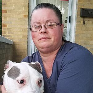 Staff member Christal posing with white pitbull